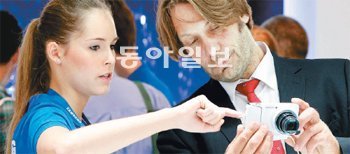 독일 쾰른에서 열린 ‘포토키나 2012’의 삼성전자 부스에서 한 관람객이 안내 직원으로부터 ‘갤럭시 카메라’의 작동 방법을 듣고 있다. 쾰른=최혁중 기자 sajinman@donga.com