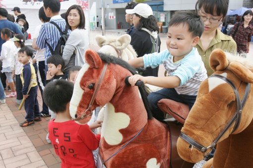 2011년 10월 과천 서울경마공원에서 열린 가을축제에서 말 모양의 놀이기구를 타고 즐거워하는 어린이들. 서울경마공원은 계절축제 
등을 통해 기존 경마장의 부정적인 이미지를 벗고 수도권을 대표하는 가족 복합레저공간으로 자리잡고 있다. 사진제공｜한국마사회