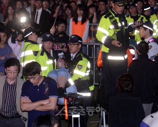 4일 밤 싸이의 서울광장 콘서트에 앞서 한 시민이 실신해 경찰들에 의해 이송되고 있다. 김종원 기자
