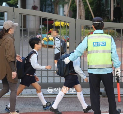 지난달 말 흉기 난동 사건이 일어난 서울 계성초등학교의 학부모들이 4일 등교하는 자녀들을 학교 앞까지 바래다주고 있다. 계성초는 사건 이후 경비업체 에스텍과 계약해 학교 안팎을 24시간 경비하도록 하고 있다. 박영대 기자 sannae@donga.com