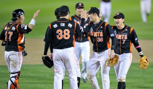 8일 서울 잠실야구장에서 열린 2012 프로야구 준플레이오프 1차전 두산베어스 대 롯데자이언츠 경기에서 연장 접전 끝에 8-5 승리를 거둔 롯데 선수들이 경기 종료 후 하이파이브 하고 있다. 잠실｜김종원기자 won@donga.com 트위터 @beanjjun