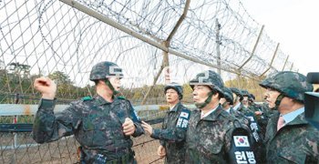 “철책 넘는데 1분도 안 걸려” 북한군 병사가 귀순한 강원 고성의 육군 22사단 예하 최전방 일반소초(GOP) 철책 앞에서 조성직 22사단장(왼쪽)이 12일 국회 국방위원회 소속 의원들에게 당시 상황을 설명하고 있다. 조 사단장은 “병사에게 재연시켜 보니 철책을 넘기까지 채 1분이 걸리지 않았다”고 말했다. 의원들은 북한군 병사가 철책을 뚫고 GOP 생활관 문을 두드려 귀순 사실을 알리기까지 군 경계태세의 문제점을 집중 추궁했다. 고성=사진공동취재단