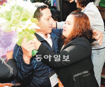 15일 경북도청 주차장에서 베트남 출신 여성 팜 티친 씨(오른쪽)가 한국을 방문한 아버지에게 꽃다발을 전하며 눈물을 글썽이고 있다. 경북도 제공