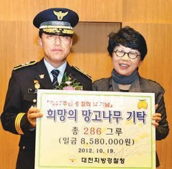 이상원 대전지방경찰청장(왼쪽)이 19일 대전 서구 둔산동 지방경찰청에서 이광희 희망의 망고나무 대표에게 성금을 전달하고 있다. 대전지방경찰청 제공