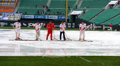 22일 오후 인천 문학야구장에서 '2012 팔도 프로야구 PO 5차전' SK 와이번스와 롯데 자이언츠의 경기가 열린다. SK 관계자들이 경기전 내린 비로인해 그라운드에 고인 물을 빼고 있다. 문학｜김민성 기자 marineboy@donga.com 트위터 @bluemarine007
