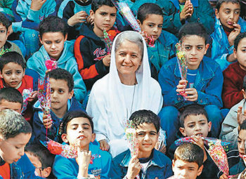 매기 고브란 여사가 모까탐 지역 아이들에게 둘러싸여 환한 미소를 짓고 있다. 아이들은 고브란 여사에게 전하는 감사의 뜻으로 한 손에 꽃을 들었다. 사진 출처 가톨릭헤럴드