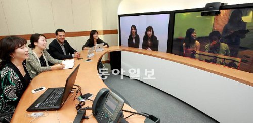 한 공간에 모여 일하는 것처럼 멀리 떨어져서도 효율적으로 일할 수 있는 기능이 추가되면서 화상회의가 보편화하고 있다. 사진은 KT 직원들이 서울 광화문 사옥과 서초 사옥, 경기 고양시 일산의 스마트워킹센터를 연결해 화상회의를 하는 모습. KT 제공