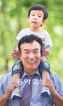 최용철 씨가 위탁받아 2년째 키우고 있는 한솔이를 목말을 태우고 환하게 웃고 있다. 이젠 친가족처럼 사랑하고 있어 그런지 얼굴도 닮아 보인다. 동방사회복지회 제공