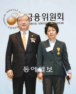 30일 서울 중구 한국프레스센터에서 열린 ‘제49회 저축의 날’ 행사에서 정부 훈장을 받은 김순자 씨(오른쪽)가 김석동 금융위원장과 기념사진을 찍고 있다. 금융위원회 제공