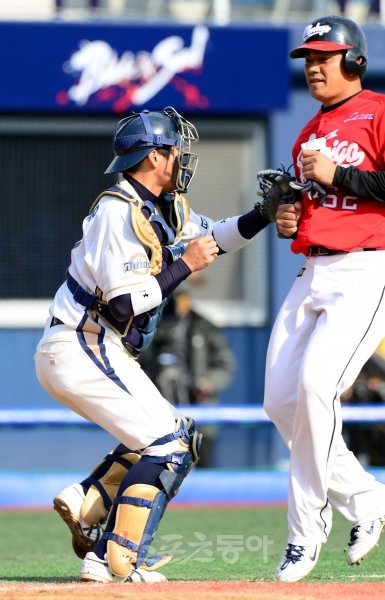 NC 포수 김태우(왼쪽)가 5일 마산구장에서 열린 대만 챔피언 라미고 몽키스와의 평가전 4회 수비 때 스퀴즈 번트를 틈 타 홈으로
 들어오던 첸진펑을 태그 아웃시키고 있다. 창원｜김민성 기자 marineboy@donga.com 트위터 @bluemarine007
