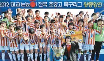 대교눈높이컵 전국초등축구리그 왕중왕에 오른 서울 신정초교 선수단이 우승컵 앞에서 환호하고 있다. 대한축구협회 제공