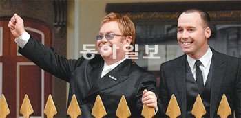 2005년 12월 21일 결혼식을 마친 엘턴 존(왼쪽)과 데이비드 퍼니시가 영국 런던 근교 길드홀의 피로연장에 도착해 하객들에게 손을 흔들고 있다. 동아일보DB