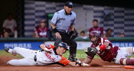 FA대박을 터트리며 호랑이 군단의 일원이 된 김주찬은 정교한 타격과 빠른 발을 자랑한다. 이용규를 보유한 KIA는 김주찬의 
영입으로 강력한 테이블세터진을 꾸릴 수 있게 됐다. 사진은 교묘한 홈 슬라이딩으로 득점에 성공하는 김주찬(왼쪽). 스포츠동아DB