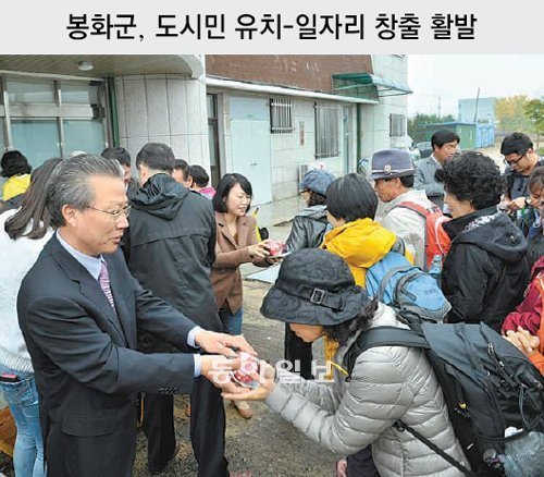 경북 봉화군은 활발한 도시민 유치와 일자리 만들기 노력으로 인구 감소세가 완화되고 지역 경제도 활력을 찾고 있다. 
봉화∼영양∼청송∼영월을 잇는 ‘외씨버선길’ 관광열차 체험 행사 참가자들에게 봉화군 관계자들이 봉화사과를 나눠주며 홍보하고 있다. 
봉화군 제공