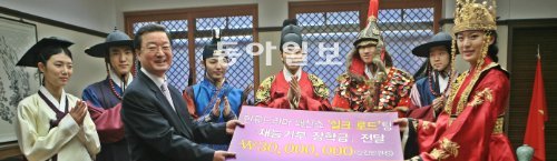 대경대 모델과 ‘비단길’ 공연팀 학생들이 19일 김은섭 총장(왼쪽)에게 패션쇼로 번 공연 수익금 3000만 원을 장학금으로 기부하고 있다. 대경대 제공