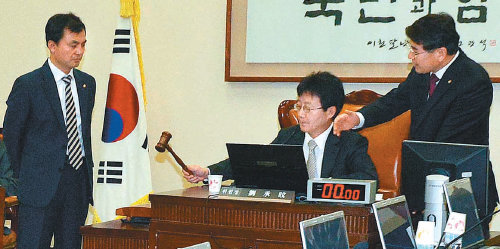 28일 국회 국방위원회 회의실에서 민주통합당 안규백(왼쪽) 김재윤 의원(오른쪽)이 항의하는 가운데 유승민 국방위원장(가운데)이 제
주해군기지 건설 예산안을 처리하고 있다. 뉴시스