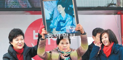 어머니의 이름으로 28일 충남 홍성군의 한 주차장에서 열린 새누리당 박근혜 대선후보의 유세현장에서 한 지지자가 고 육영수 여사의 사진 액자를 들어 보였다. 왼쪽은 박 후보. 홍성=김동주 기자 zoo@donga.com