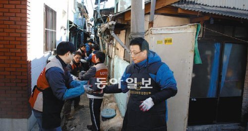 롯데건설 임직원들이 27일 부산 동구 범일5동 저소득 79가구에 연탄을 배달하고 있다. 롯데건설 제공