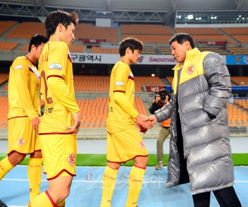 28일 저녁 대구 스타디움에서 열린 프로축구 2012 K-리그 대구FC와 광주FC의 경기에서 2-0으로 패한 광주FC 선수들이 침울한 표정으로 그라운드를 내려오는 가운데 최만희 감독이 선수들을 격려하고 있다. 대구ㅣ박화용 기자 inphoto@donga.com 트위터 @seven7sola