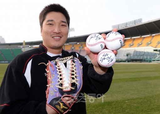 LG와 4년 총액 34억원에 재계약한 이진영이 잠실벌에 섰다. ‘국민우익수’의 글러브는 LG 외야를 계속 지키게 됐다. 트위터 
인터뷰를 마친 그가 팬들에게 선물할 친필 사인볼을 들고 웃고 있다. 잠실｜김종원 기자 won@donga.com 
트위터@beanjjun