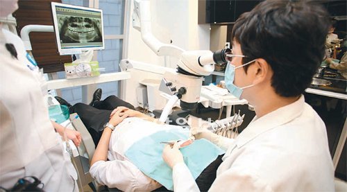 에스플란트치과병원 이종호 원장이 미세광학현미경을 보면서 환자의 신경치료를 하고 있다.