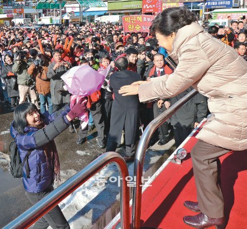 꽃다발 받는 朴 새누리당 박근혜 대선후보가 6일 오후 경기 안산시 단원구 고잔동 유세장에서 연설하기 전 한 여성 지지자로부터 꽃다발을 받고 있다. 안산=김동주 기자 zoo@donga.com