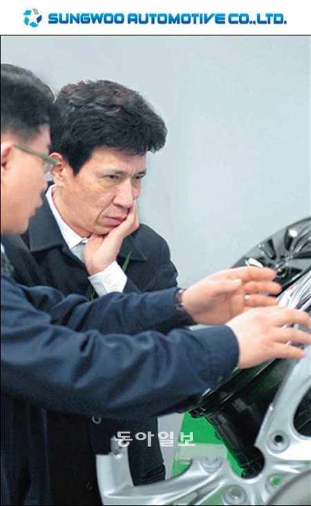 정몽용 성우오토모티브 회장(왼쪽에서 두 번째)이 자사가 생산하는 알루미늄휠을 살펴보며 직원의 설명을 듣고 있다. 성우오토모티브 제공