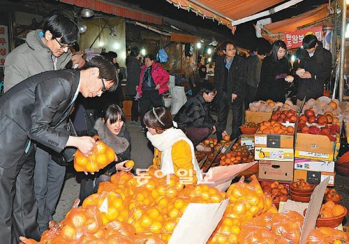 인근 시장 상인들과 상생교류를 확대하고 있는 롯데백화점 대구점 직원들이 11일 오후인근 번개시장에서 과일을 고르고 있다. 장영훈 기자 jang@donga.com