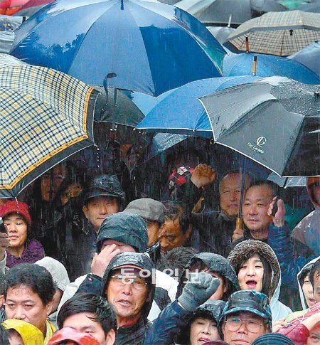 비도 못 막은 유세 열기 14일 겨울비가 내리는 중에도 유권자들을 향한 대선후보들의 호소는 이어졌다. 한 유세현장에서 시민들이 비를 맞으며 후보들의 이야기에 귀를 기울이고 있다. 박영대 기자 sannae@donga.com