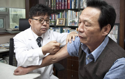 서울 노원구에 위치한 위앤장이원표내과의원을 찾은 한 노인환자가 이원표 회장으로부터 폐렴구균 백신에 대한 설명을 듣고난 뒤 예방접종을 받고 있다.