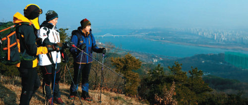 산과 강의 경치를 함께 볼 수 있는 아차산은 서울의 유명한 ‘해돋이 명소’다. 17일 오전 서울 광진구 아차산에 오른 손용식 강사(가운데)가 신창수(25), 김수현 씨(28·여)에게 겨울철 해맞이 산행 노하우를 알려주고 있다.김경제 기자 kjk5873@donga.com