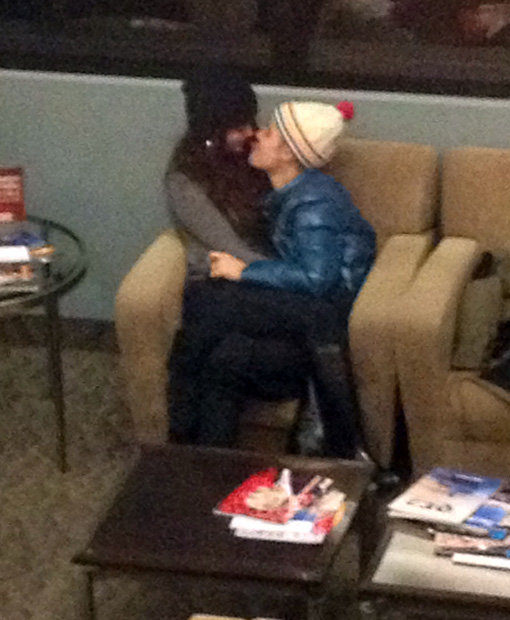 저스틴 비버와 셀레나 고메즈가 솔트레이크시티 국제공항 내 의자에 앉아 진한 스킨십을 나누고 있다. 사진제공｜TOPIC / Splash News