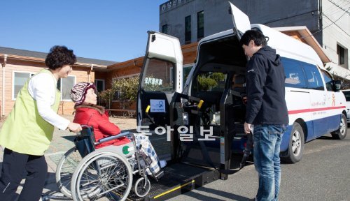 사회적기업 ‘안심생활’의 주부사원이 경남 양산시 서창지점에서 병원 진료를 받아야 하는 할머니를 현대자동차가 지원한 휠체어 리프트 차량에 태우고 있다. 안심생활 제공