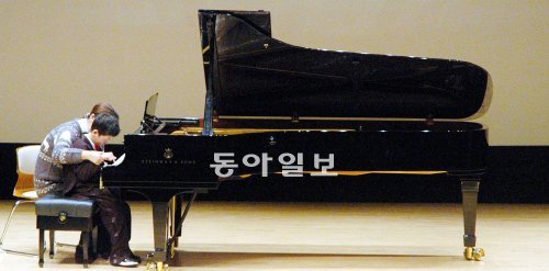 15일 계명대 해담아트홀에서 열린 뮤직바이러스 음악회 무대에 오른 반창근 군이 전담 교사의 도움을 받아 피아노를 연주하고 있다. 계명대 제공