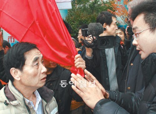 중국 광둥 성 광저우 시에서 발행되는 주간지 난팡주말의 기자들이 이틀째 파업 중인 8일 회사 정문 앞에서 파업을 지지하는 한 
시민(오른쪽)이 파업을 저지하려는 측 인사와 언쟁을 벌이고 있다. 광저우=고기정 특파원 koh@donga.com