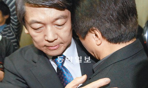 安 대선후보 사퇴 기자회견 직후 지난해 11월 23일 안철수 무소속 대선후보(왼쪽)의 갑작스러운 후보직 사퇴는 그를 통한 새 정치의 희망을 키워가던 중도 세력에 깊은 슬픔과 좌절감을 줬다. 사진은 당시 사퇴 기자회견 직후 울고 있는 캠프 관계자를 포옹하며 위로하고 있는 안 후보. 동아일보DB