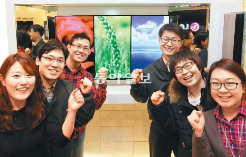 LG디스플레이 OLED TV 개발1담당 오창호 상무(오른쪽에서 세 번째)를 비롯한 연구진이 18일 경기 파주시 LG디스플레이 전시장에 설치된 OLED TV 앞에서 파이팅을
외치고 있다. LG디스플레이 제공