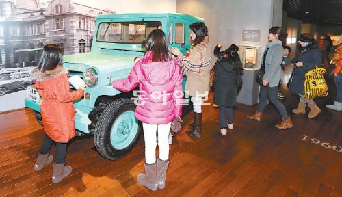 25일 서울 종로구 세종로 대한민국역사박물관에서 시민들이 헌 자동차 부품으로 만든 첫 국산 자동차 ‘시발택시’를 신기한 듯 만져보며 감상하고 있다. 이훈구 기자 ufo@donga.com