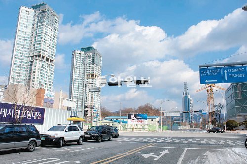 대전 유성구 도룡동 스마트시티아파트(왼쪽) 주민들이 아파트 앞 갑천 쪽에 20층짜리 오피스텔(오른쪽 크레인 부분) 건축에 반발하고 있다. 이기진 기자 doyoce@donga.com