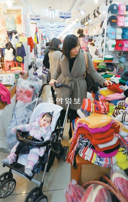 아이를 유모차에 태운 주부가 2일 오후 서울 중구 남창동 남대문시장 서울원아동복 상가 매장에 진열된 유아용 모자를 둘러보고 있다. 최근 남대문시장 아동복 상가 일대에는 젊은 주부들의 발길이 끊이질 않고 있다. 장승윤 기자 tomato99@donga.com