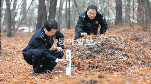 ‘무연고자 분묘’를 어루만지는 장보익 의정부교도소 소장(왼쪽)과 윤창식 총무과장. 이들은 “죄는 미워도 사람이 밉지는 않다. 가족에게도 버림받은 이들이라 안타깝다”고 했다. 의정부=장승윤 기자 tomato99@donga.com