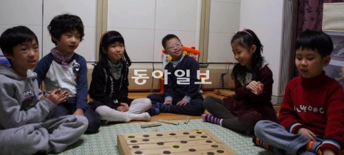 유진어린이집 졸업식을 이틀 앞둔 18일, 다운증후군을 앓고 있는 안주영 군 집에 어린이집 친구들이 놀러와 윷놀이를 하고 있다. 왼쪽부터 김태희 김민석 군, 지서희 양, 안 군, 최승아 양, 정지현 군. 김도형 기자 dodo@donga.com