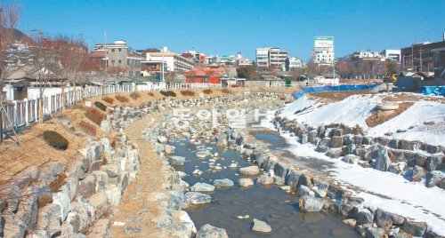 덮여 있던 콘크리트를 걷어내고 하천의 모습을 갖춘 춘천시 약사천. 눈이 녹은 물이 군데군데 고여 있다. 약사천 복원공사는 다음 달 시험 통수에 이어 6월 마무리된다. 이인모 기자 imlee@donga.com