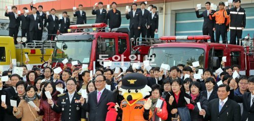 21일 부산 영도구 동산동 부산항만소방서에서 소방 관계자 150여 명이 생명나눔 장기기증 서약서를 든 채 환하게 웃고 있다. 부산=서영수 기자 kuki@donga.com