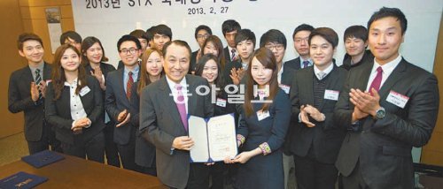 강덕수 STX장학재단 이사장(STX그룹 회장·앞줄 왼쪽)이 지난달 27일 서울 중구 남대문로 STX남산타워에서 한 장학생에게 장학증서를 주며 활짝 웃고 있다. STX그룹 제공