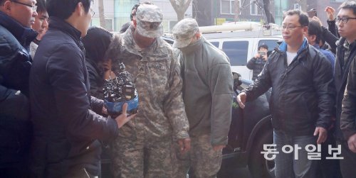 얼굴 가리고… 경찰에 출석한 미군 3일 서울 도심에서 경찰과 시민을 차로 치고 시속 170km가 넘는 속도로 도망쳤던 주한미군 중 한 명인 크리스천 하사가 군복으로 얼굴을 가린 채 4일 오후 2시경 용산경찰서에 들어서고 있다. 동승했던 웬디 상병(여)은 오후 6시경 경찰에 출석했고 차량을 운전하다 경찰이 쏜 총에 맞은 리처드 딕슨 상병은 치료를 이유로 출석하지 않았다. 변영욱 기자 cut@donga.com