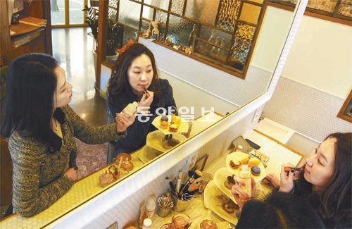 3일 오전 서울 마포구 서교동 ‘에이티 폭스 카페’를 방문한 여성들이 ‘파우더 룸’에서 화장품을 사용하고 있다. 에이티 폭스 제공