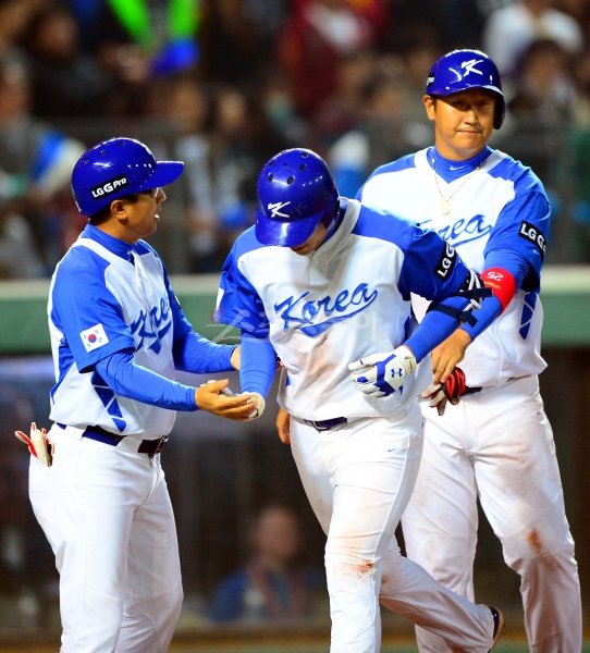 강정호(가운데)가 제3회 월드베이스볼클래식(WBC) 1라운드 대만과의 3차전에서 8회 역전 결승 2점홈런을 친 뒤 박정태 타격코치(왼쪽)와 이대호의 환영을 받고 있다. 홈런을 치고도 고개를 푹 숙인 그의 모습에서 한국야구의 위기감이 느껴진다. 타이중｜박화용 기자 inphoto@donga.com 트위터 @seven7sola