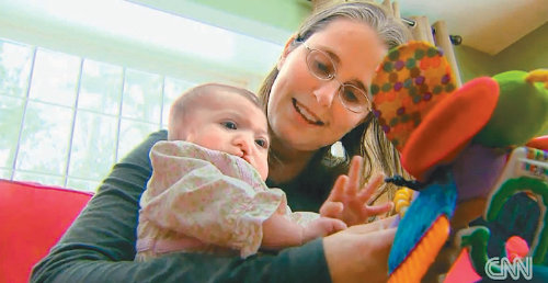 대리모 크리스털 켈리 씨가 자신이 낳은 ‘베이비 에스(S)’를 안고서 즐거운 시간을 보내고 있다. 아기의 입술이 구순구개열로 인해 갈라져 있는 것이 보인다. CNN 홈페이지