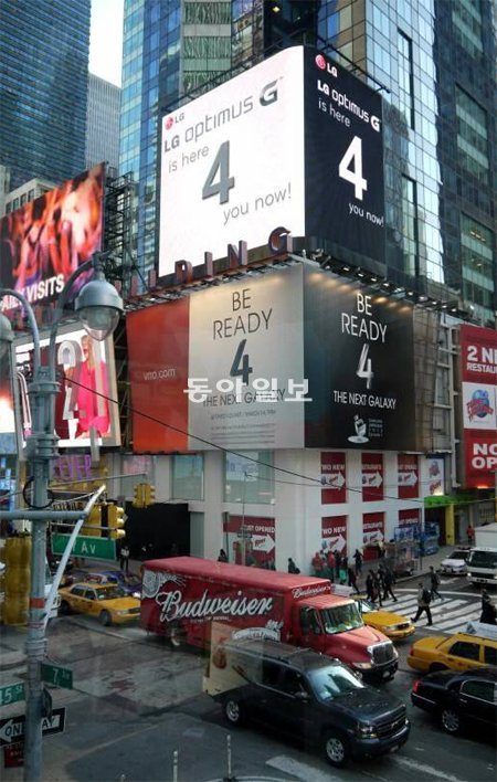 미국 뉴욕 타임스스퀘어에 설치된 삼성전자(아래)와 LG전자(위)의 광고판. LG전자는 삼성전자의 ‘갤럭시S4’를 겨냥해 숫자 4를 강조한 ‘옵티머스G’의 새 광고를 13일(현지 시간)부터 내보냈다. LG전자 제공
